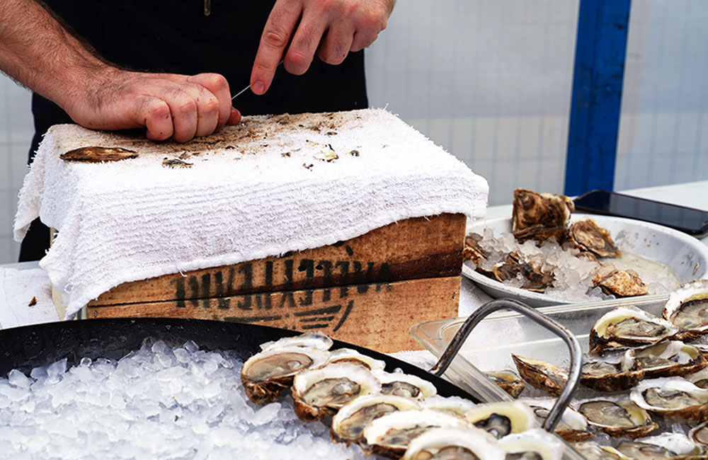 Food Stations Catering Menu For Events — Oyster's being Shucked at a Food Station at an Event in Toronto